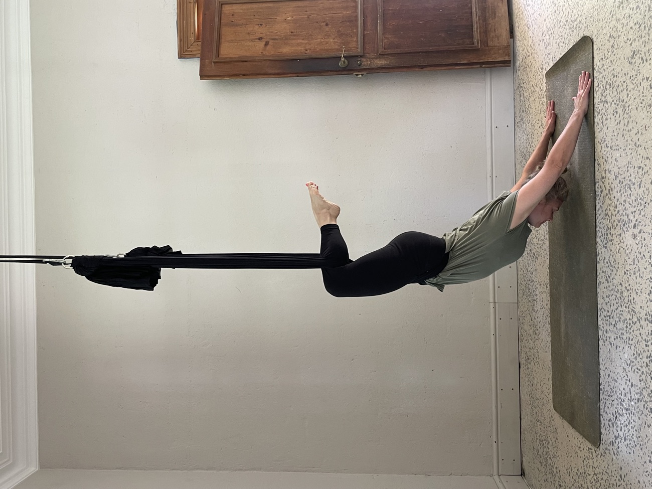 Aerial yoga inversion supported in silk hammocks at b.YOGA Practice