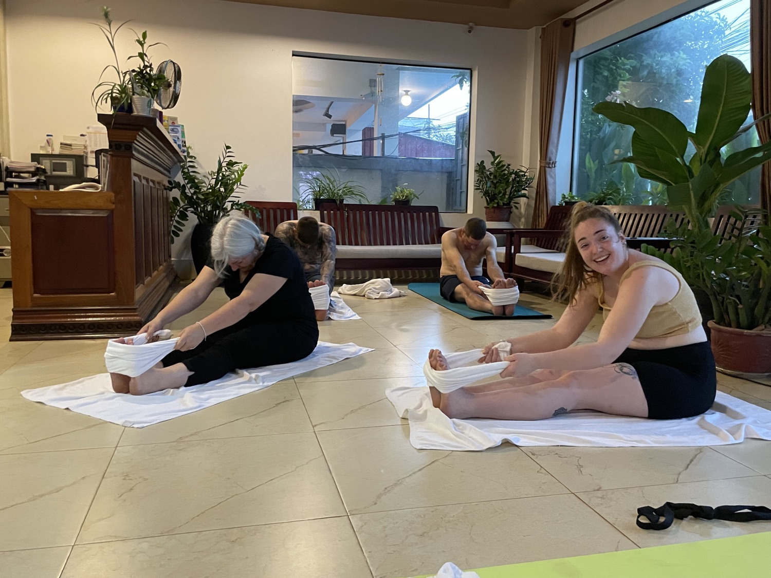 Smiling students stretching together in a warm group yoga class